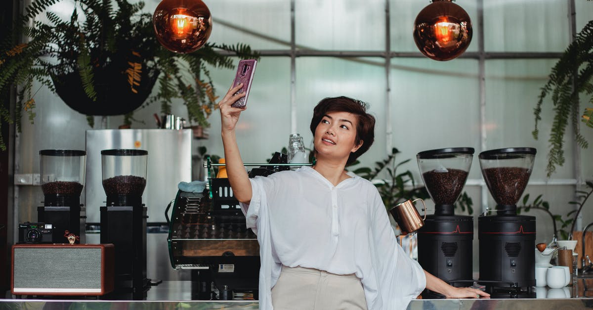 Can I use my dehydrator to raise bread? - Cheerful Asian female with short brown hair in casual clothes standing against coffee machine and taking selfie on smartphone