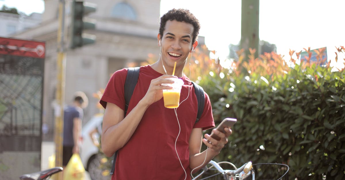 Can I use orange juice to pasteurize egg whites? - Happy young man using smartphone on street