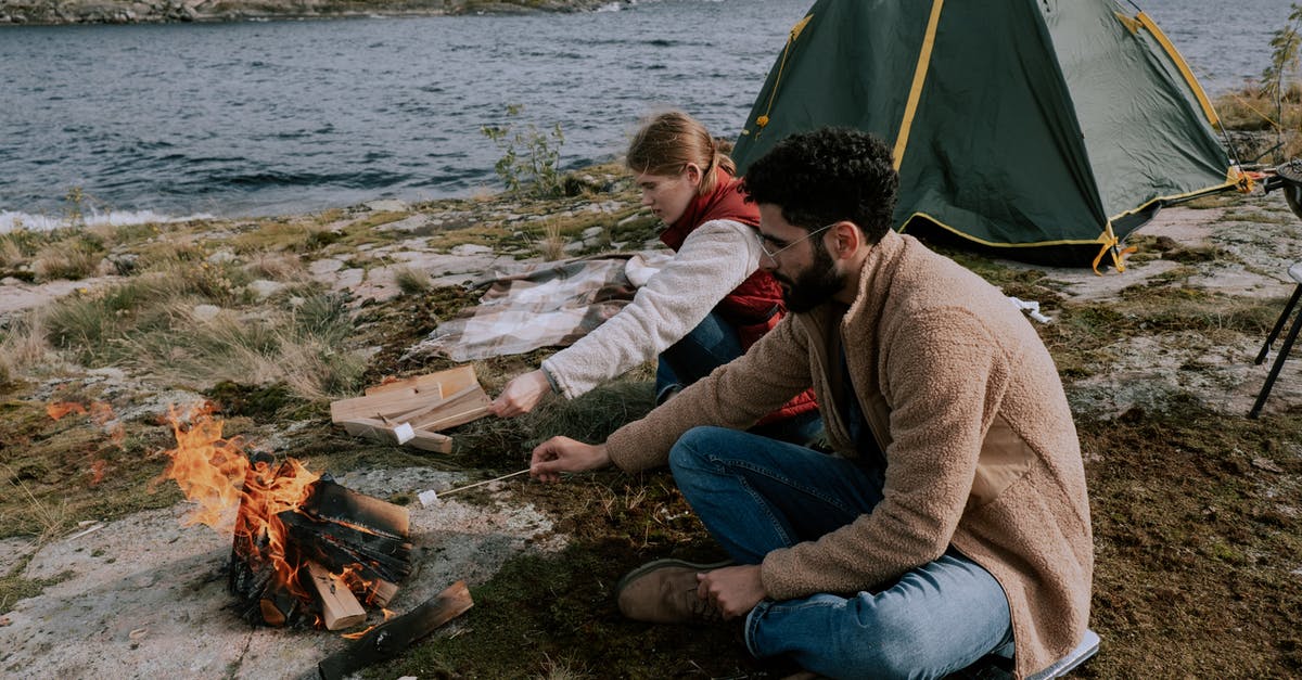 Can I use this dutch oven on a grill or camp fire? - Couple Sitting on Ground Beside Bonfire with Marshmallows