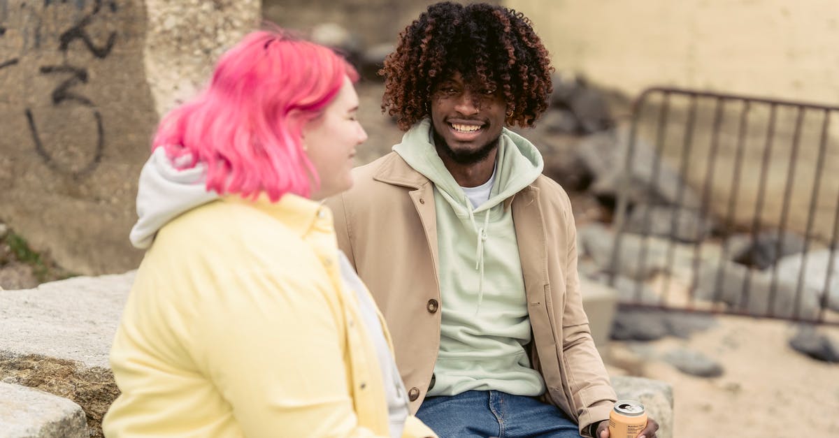 Can I utilise a baking stone to make crepes? - Cheerful multiracial couple with cans of soda sitting on stones on embankment near river while spending time together during date