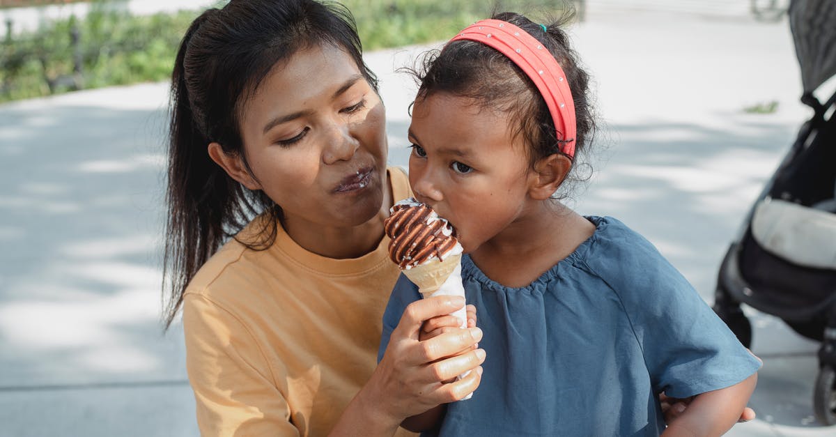 can ice help with spicy food? - Happy ethnic mother feeding daughter with tasty sweet ice cream