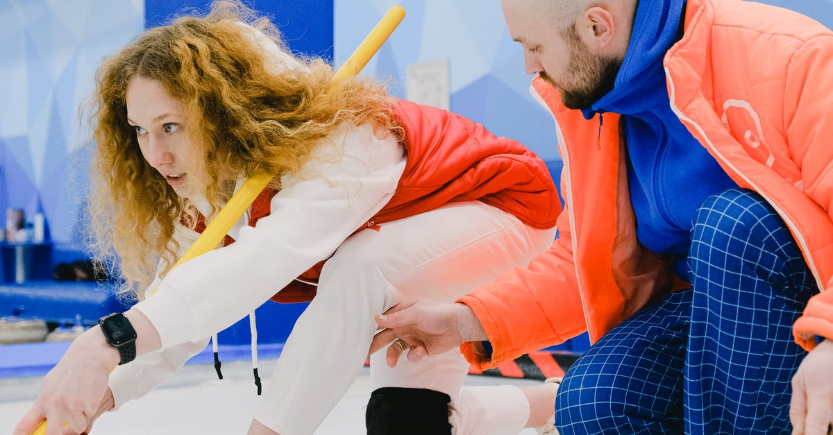 can ice help with spicy food? - Man trainer fixing leg position of woman player in curling