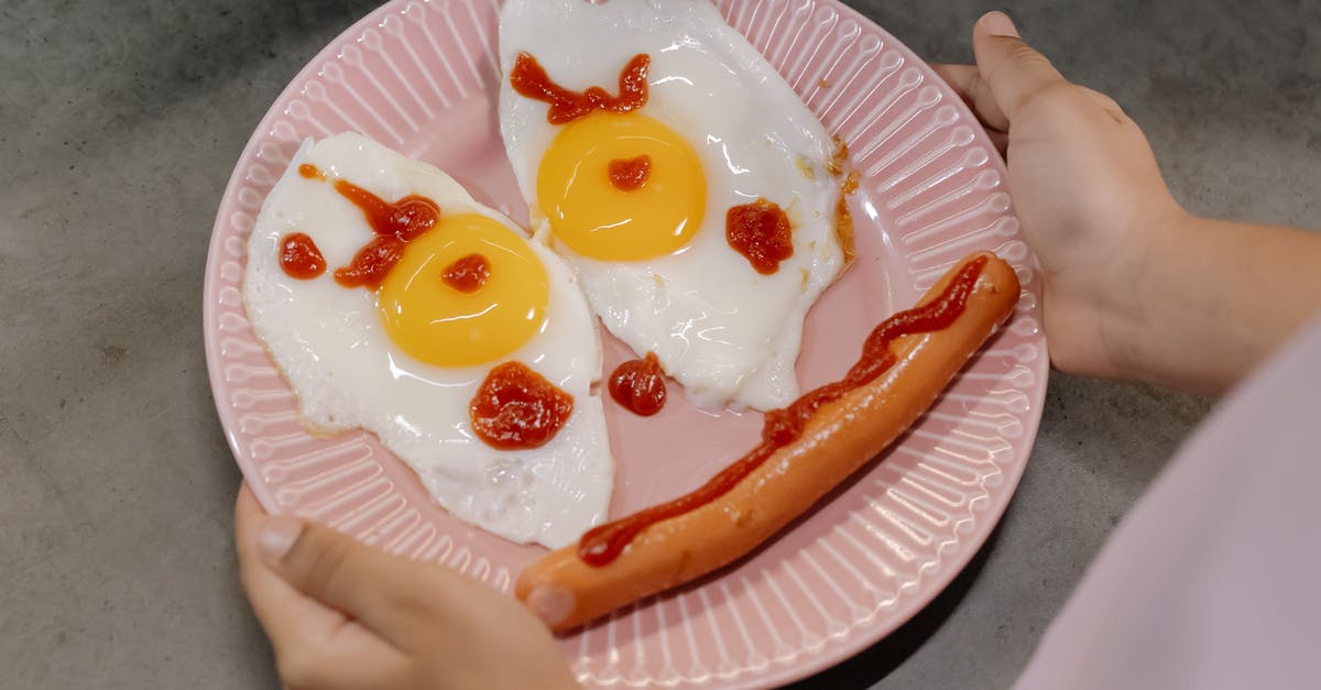 Can one use cooked egg to make fried eggs (sunny side up)? [duplicate] - A Smiley on a Plate Made of Sunny Side Up Eggs and a Sausage