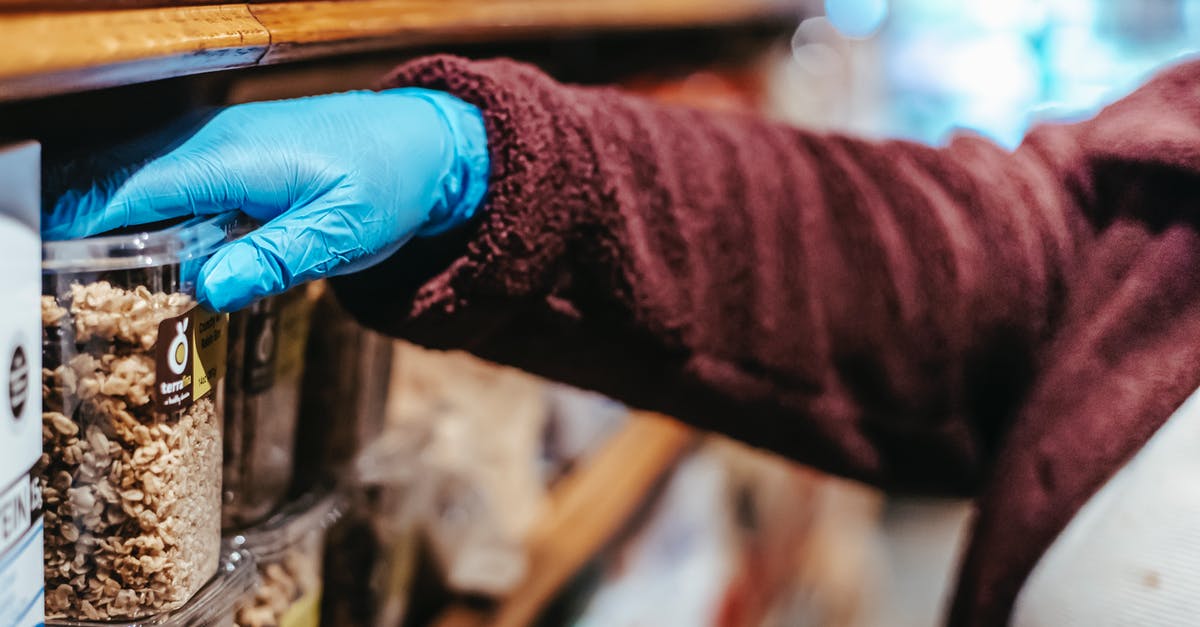 Can plastic grocery store misters be used for oil? - Crop anonymous woman in latex gloves picking food in plastic container while shopping in grocery store