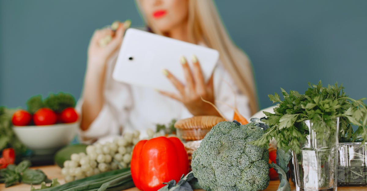 Can tomato paste be substituted for tomato purée? - Studio Shot of Vegetables on Table and Woman with Tablet in Background