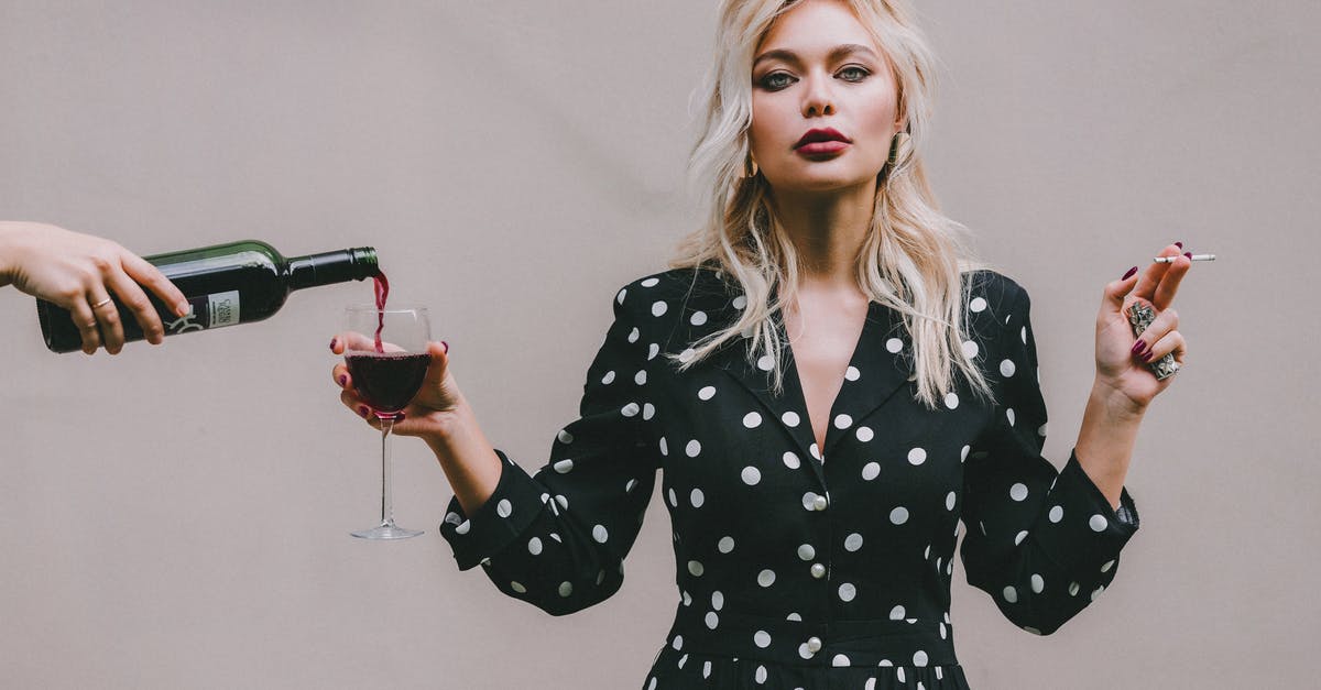 Can wine gone bad be bad for you? - Confident woman standing with wineglass and cigarette