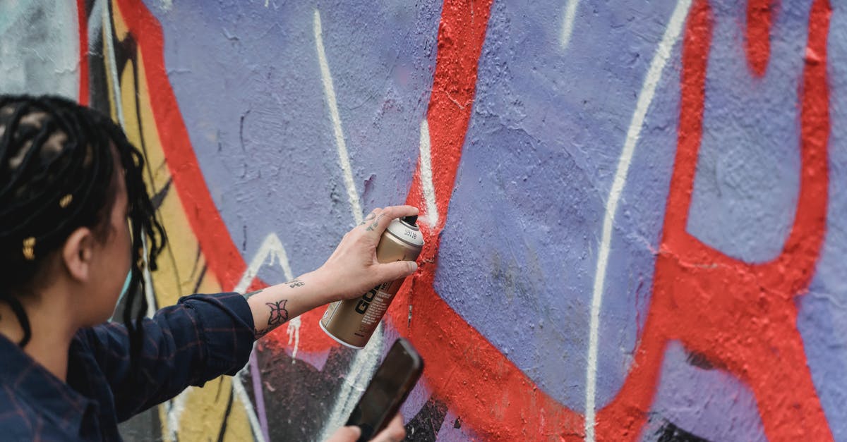 Can you create brown butter directly from heavy cream? - From above side view of crop faceless female artist with braided hair painting graffiti on wall while standing on street