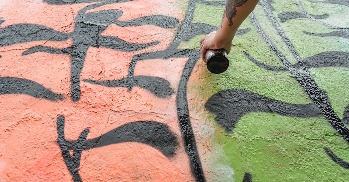 Can you create brown butter directly from heavy cream? - From below of crop anonymous talented painter with tattoo spraying paint on wall with colorful patterns on street in city