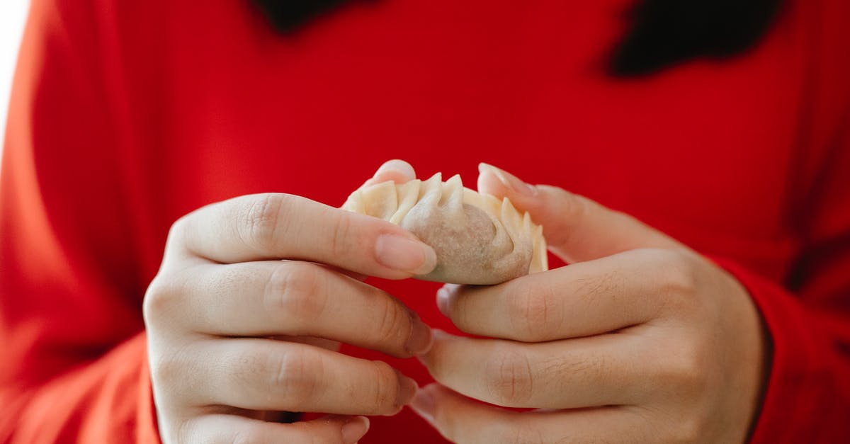 Can you fold dough during autolyse? - Crop faceless female folding traditional Asian jiaozi dumplings during dinner preparation in kitchen