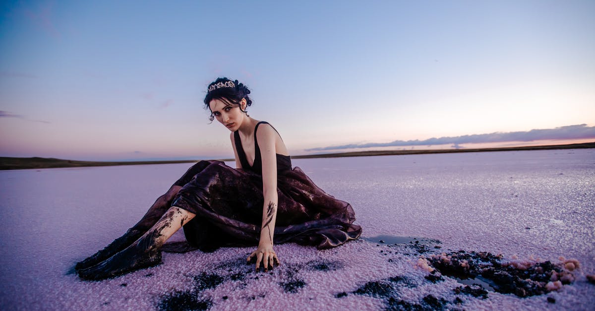 Can you freeze whole pomegranates to save them? - Full body of elegant female covered with black oil looking at camera while sitting on contaminated snowy terrain in nature