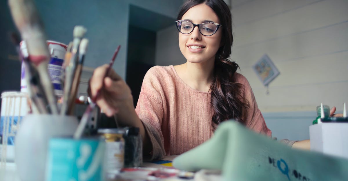 Can you make latte-art with a panarello wand? - Woman in Brown Long-sleeved Shirt Wearing Eyeglasses Holding Paint Brush