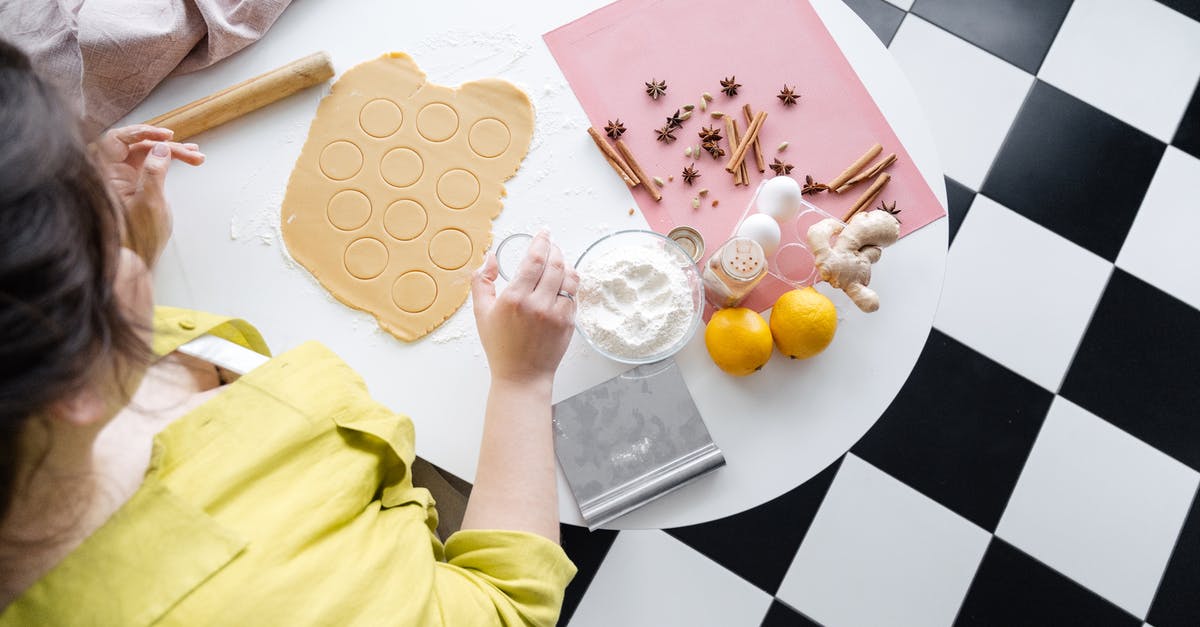 Can you use cookie cutters on sticky dough? - From above of crop anonymous female cook at table and cutting fresh dough for cookies near ginger and cinnamon sticks and bowl with flour