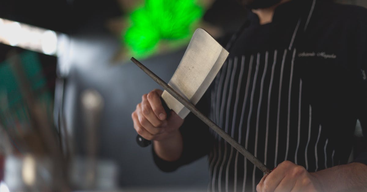 Can you use regular knife sharpeners on damascus steel? - Man Wearing an Apron Sharpening a Knife