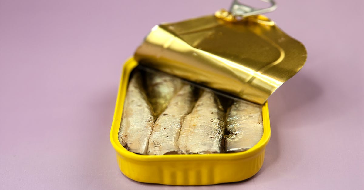 Canned yams vs. fresh - Canned fish in package on lilac background