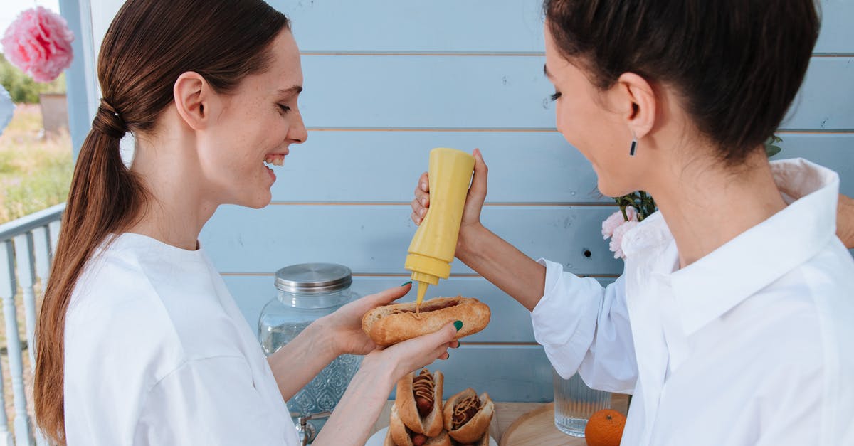 canning a mustard vinegar sauce - Women Putting Mustard on Hotdog Sandwich