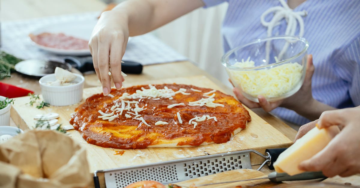 Canning sauce time - Woman sprinkling cheese on pizza