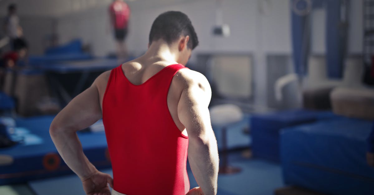 Cannot Get My Starter to Start - Back view of muscular athlete in red uniform preparing for training in gymnast hall with equipment
