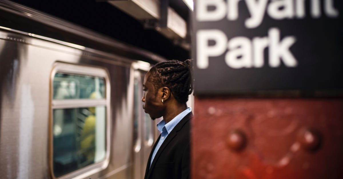 Can/should I use rapid rise yeast for longer proofing? - Side view of smart African American male with cellphone in hand waiting for arriving subway train to stop