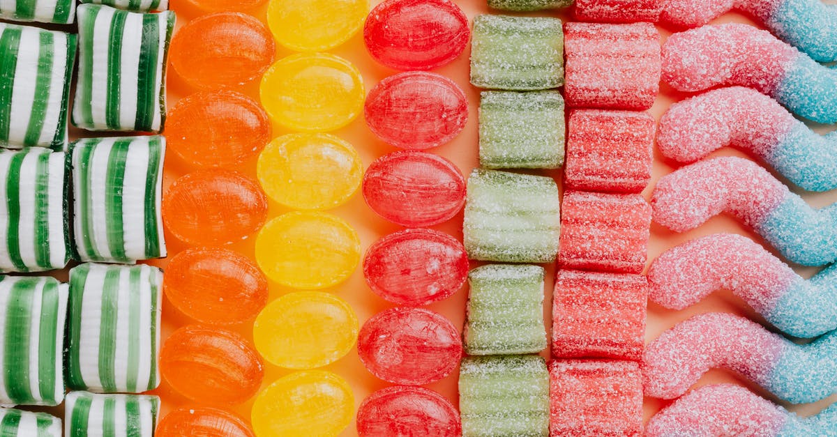 Caramel with sugar granules - From above of various delicious jelly and caramel sweets arranged in rows by type and color in modern candy store