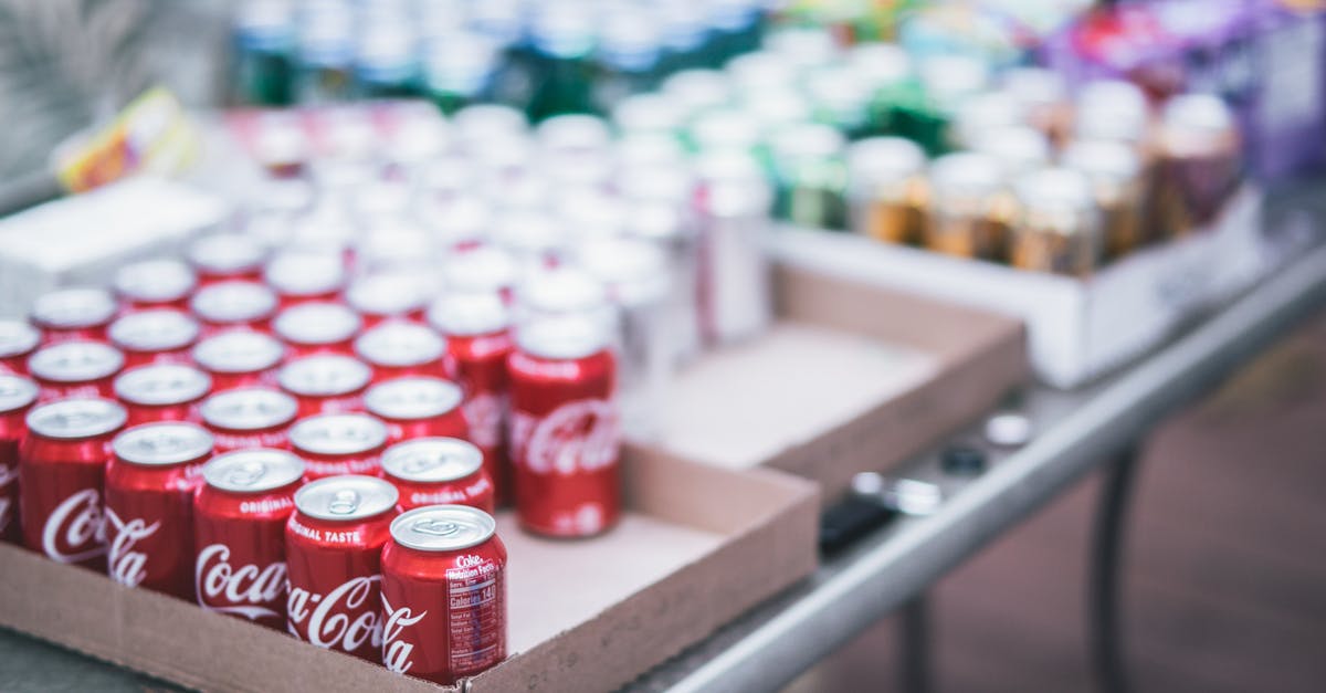 Carbonated Beverage in Pressure Cooker - Selective Focus Photography of Red Coca-cola Can Lot on Box