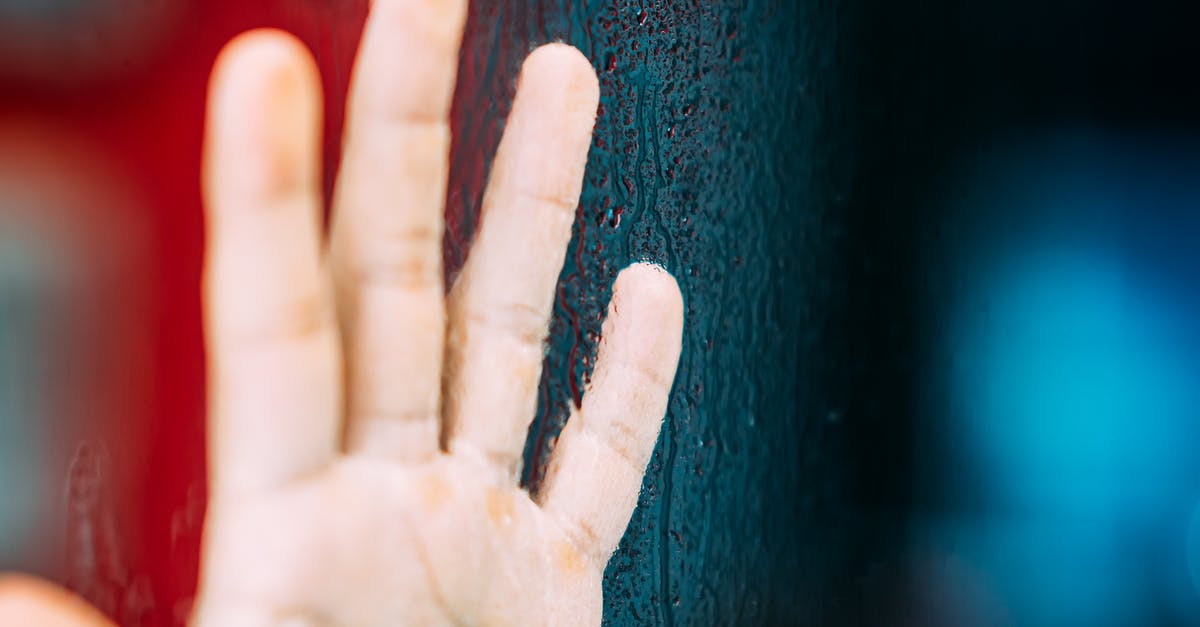 Carrots turning dark at heads, and on skin after chopping? - Crop unrecognizable person showing raised hand with calluses illuminated by colorful light near tree trunk