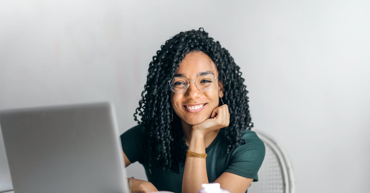 Casein content after curdling - Happy ethnic woman sitting at table with laptop