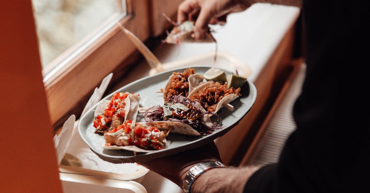 Cayenne stripes inside fried chicken strips how is it made? - Unrecognizable male with plate with various tacos near containers