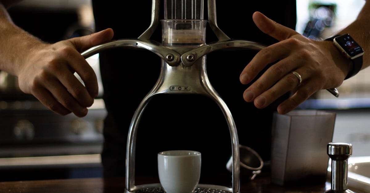 Ceramic vs Stainless Steel in coffee mugs - Crop anonymous slim male in wristwatch and golden ring using stainless steel manual drip coffee machine with ceramic cup while preparing hot drink at home