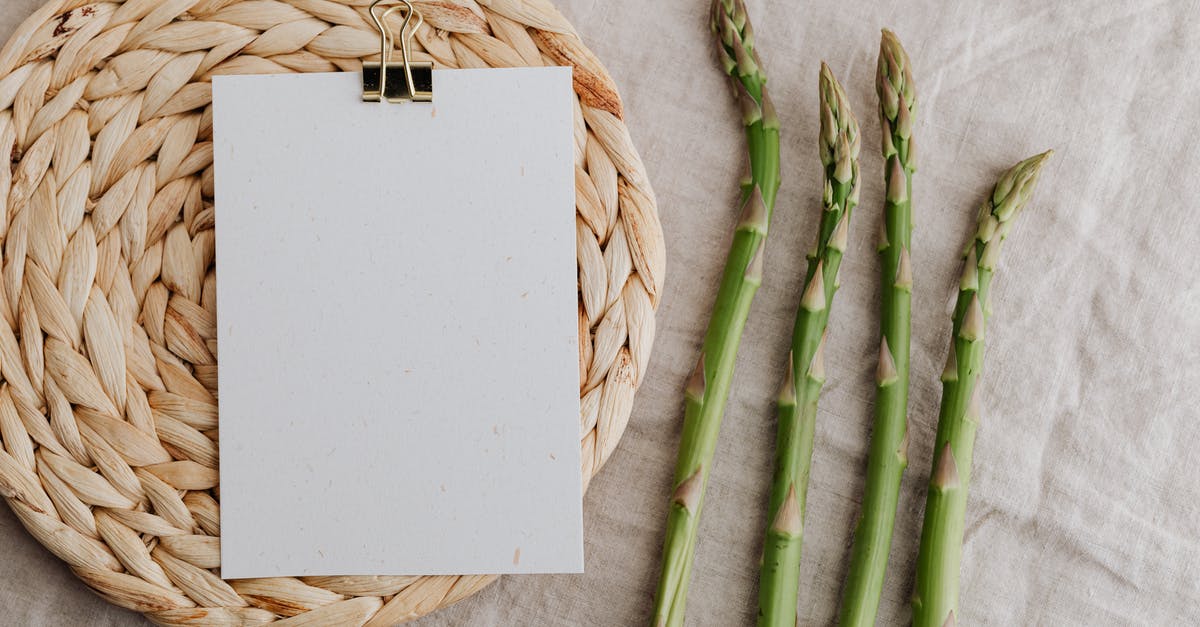 Changing a vegan cookie recipe? - From above of four fresh green asparagus sprouts and blank sheet of paper over round wicker placemat laid on white tablecloth