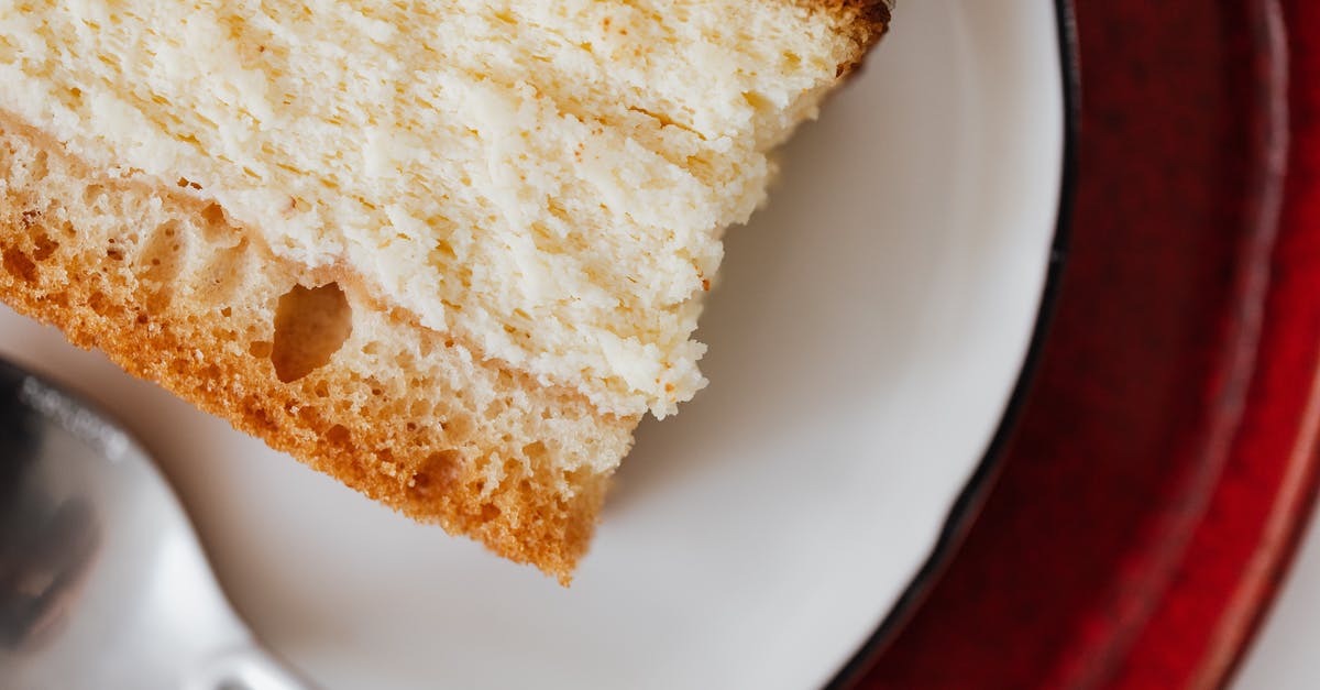 Cheapest place to get bulk chocolate? - Closeup of red plate placed under white plate with appetizing piece of cake near tea spoon on table