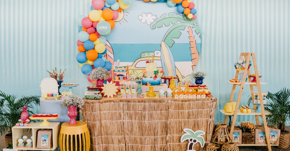 Cheapest place to get bulk chocolate? - Birthday area with colorful balloons over decorated table with festive cake and presents