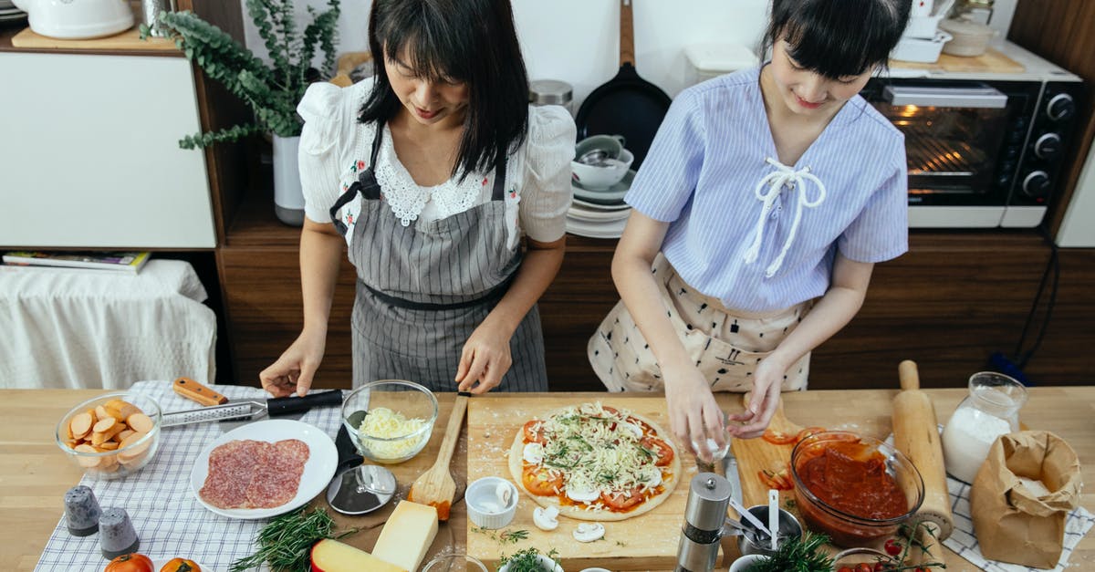 Cheese sauce without flour? - Ethnic women cooking pizza in kitchen