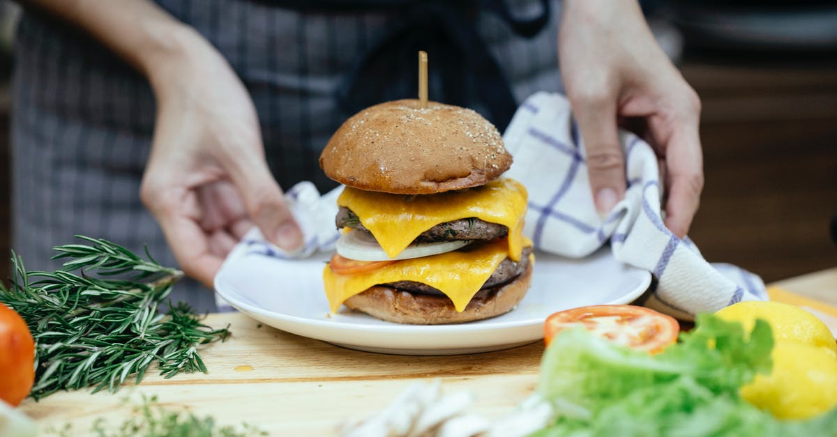 Cheese suggestions to replace melted Velveeta - Faceless cook with tasty cheeseburger on plate at home