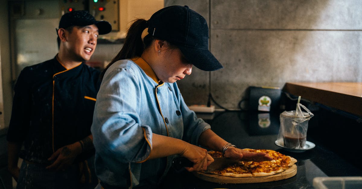 chef's knife for cutting chicken, or butcher's - A Woman Cutting a Pizza with a Knife