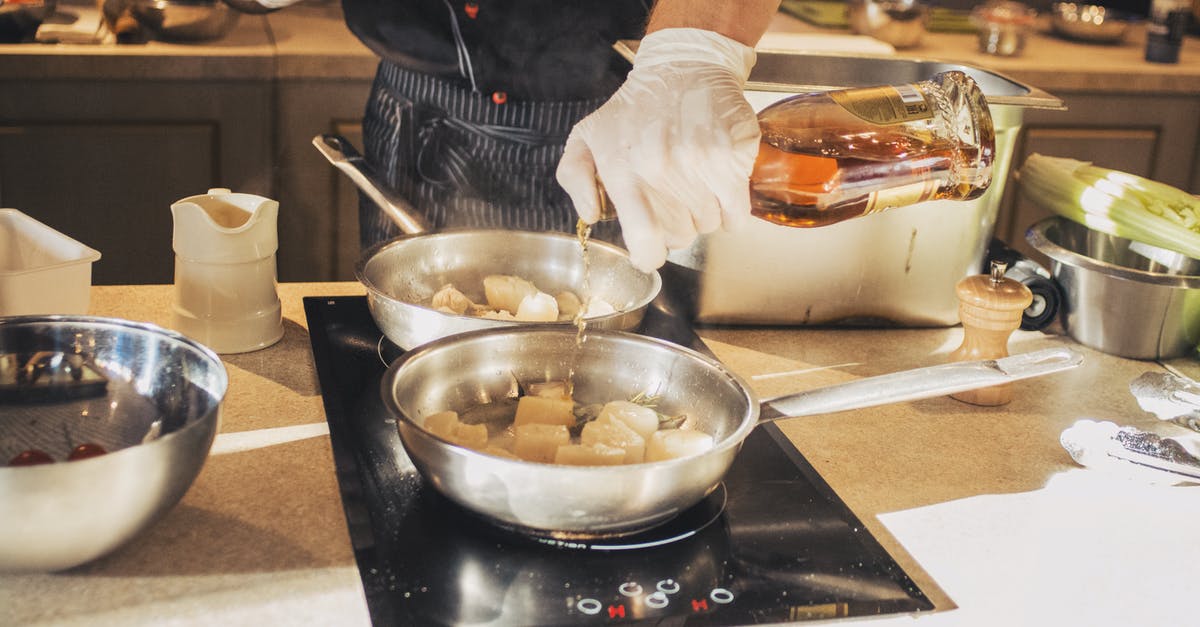 Chef at restaurant seemed to be using really flimsy pans - Photo Of Person Holding Bottle