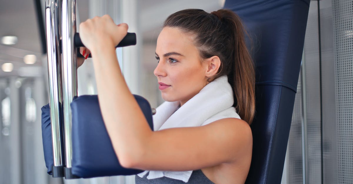 Chest Freezer TOO full? - Young determined sportswoman doing exercise on weight machine in modern sports club