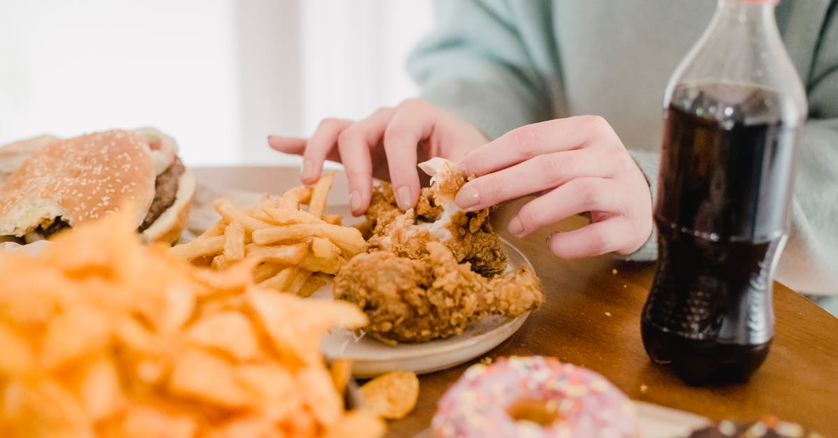 Chicken enchiladas still safe to eat [duplicate] - Woman eating fried chicken and fries at table with lemonade