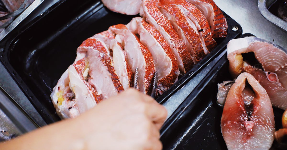 Chicken: take meat off bone before or after cooking? - Person taking steak of fresh fish