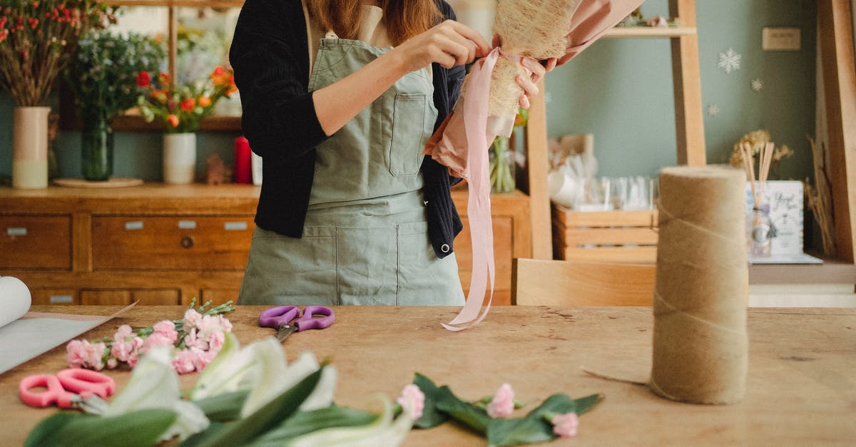 Chinese pork jerky: what makes them so tender, how do you make it? - Crop unrecognizable female florist wearing apron standing near table in contemporary light floristry shop and arranging bouquets