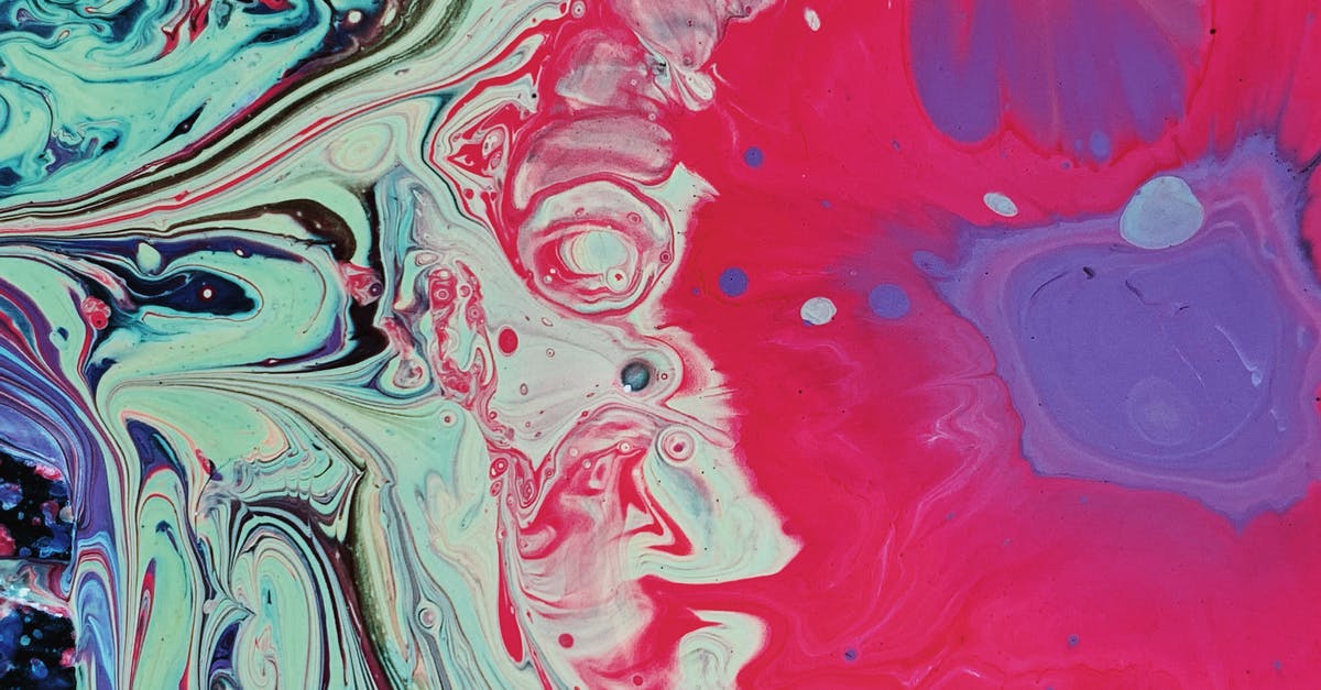 Chocolate and oil mixed - Overhead of bright red circle with a purple center and small drops and smooth fusion of multicolored paints