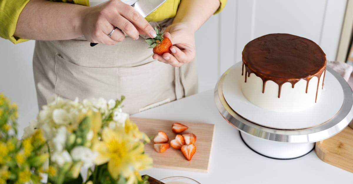 Chocolate Berry Cake with Berries as main batter ingredient? - Woman cutting strawberry for decoration of cake