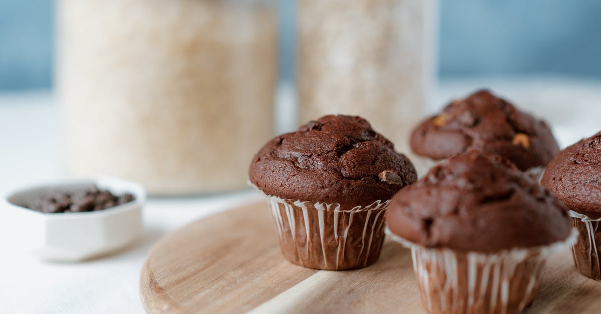 Chocolate chip substitutions - Tasty soft muffins with chocolate chips in paper liners on table on blurred background