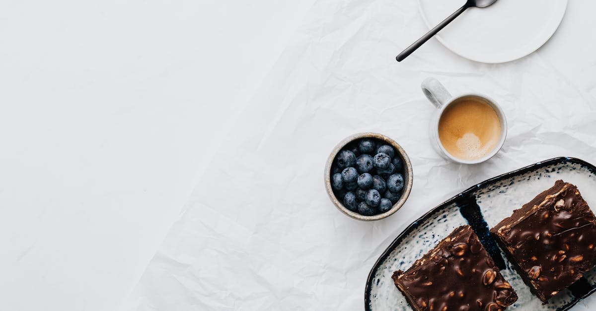 Chocolate fondant vs. liquid chocolate cake - Black Berries on White Ceramic Plate Beside Stainless Steel Spoon and White Ceramic Mug