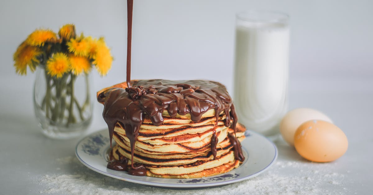 Chocolate ganache - Arrangement of appetizing sweet homemade cupcakes being topped with chocolate sauce and served with glass of fresh milk near delicate yellow flowers