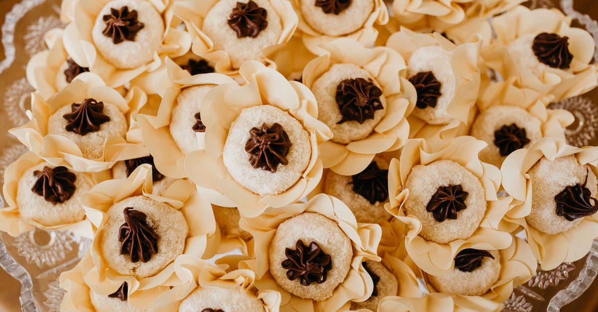 Chocolate ganache - Top view of tasty round shaped biscuits with chocolate cream in decorative flowers on transparent plate during festive event