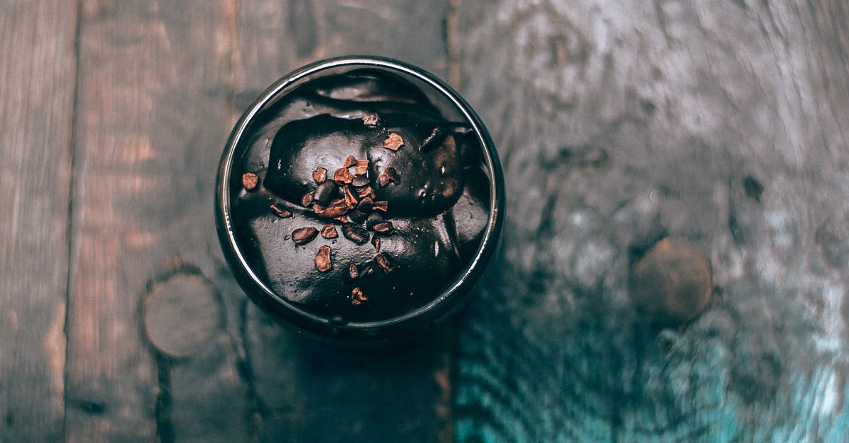 Chocolate mousse turned to scrambled eggs in cream - Cup of yummy chocolate dessert served on wooden surface