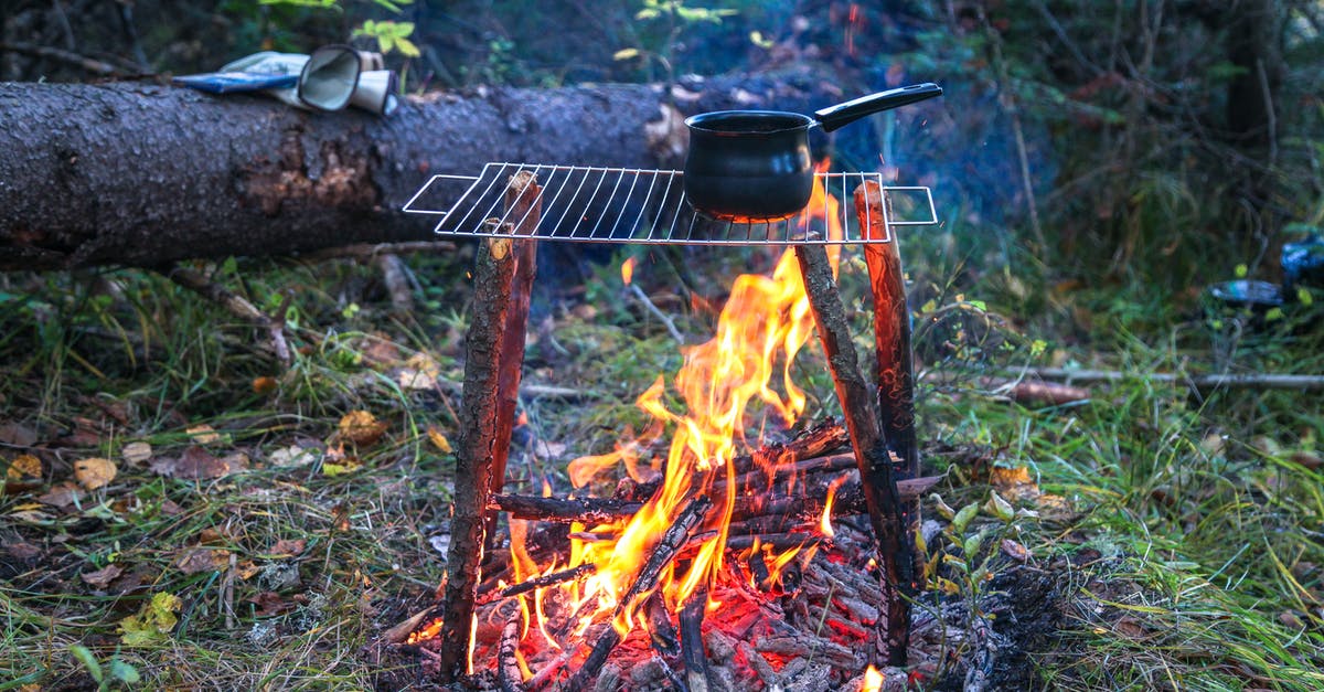 choosing a saucepan material for creams and caramels - Bonfire and rack with saucepan in woods