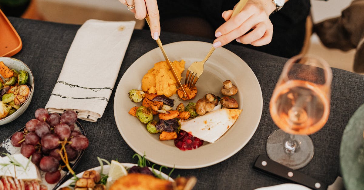 Choosing a wine that complements a meal [closed] - Person Holding Fork and Knife Slicing Vegetable on White Ceramic Plate