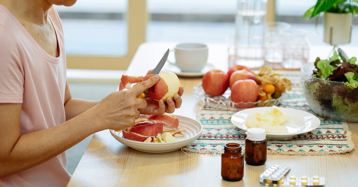 Choricitos a la sidra -- raw or cured? - Crop Asian woman peeling apples at table with various medicines