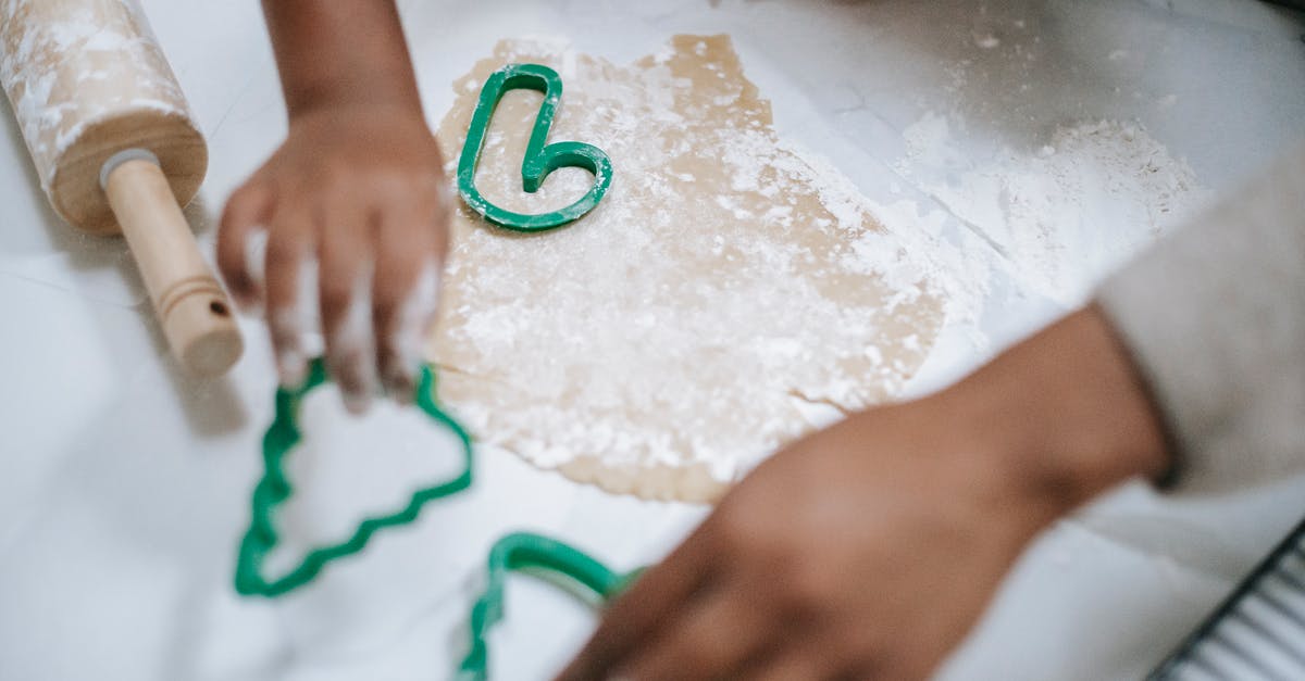 Choux pastry, general questions with gluten free flour - From above of crop anonymous black kid and parent using decorative pastry cutters on table with dough